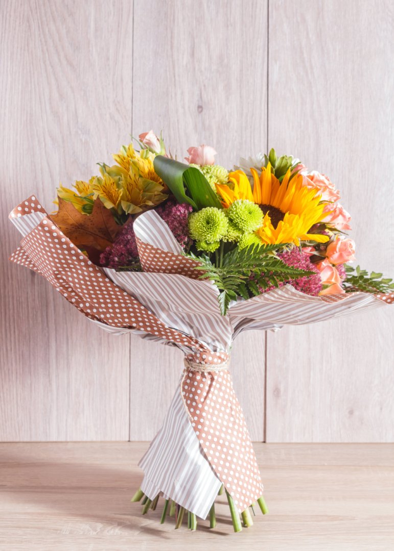 Vibrant bouquet with sunflowers and mixed flowers on wooden background